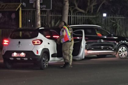 Traffic officer inspecting cars at night in South Africa.