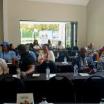 Conference attendees sitting at tables in a room.