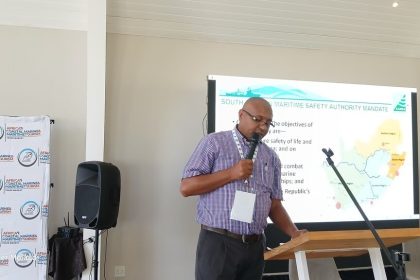 Man presenting at maritime safety conference with map.