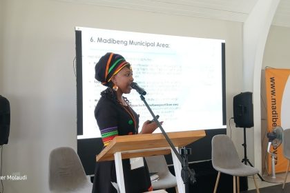 Woman presenting at Madibeng Municipal event.