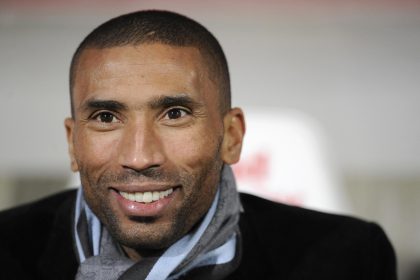 Smiling man wearing a scarf and jacket.