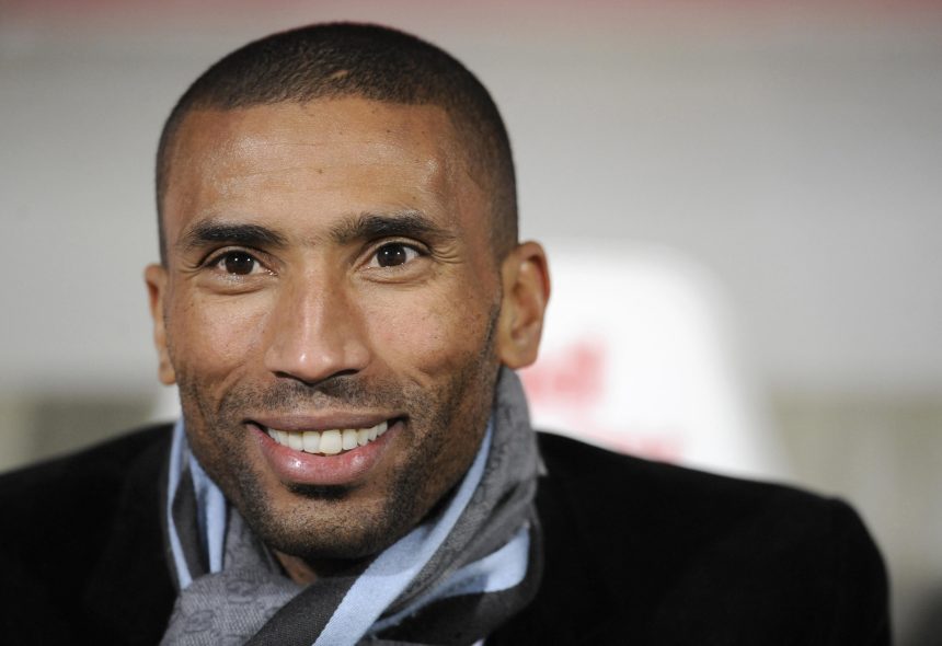 Smiling man wearing a scarf and jacket.