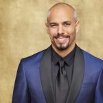 Bald man in blue suit smiling