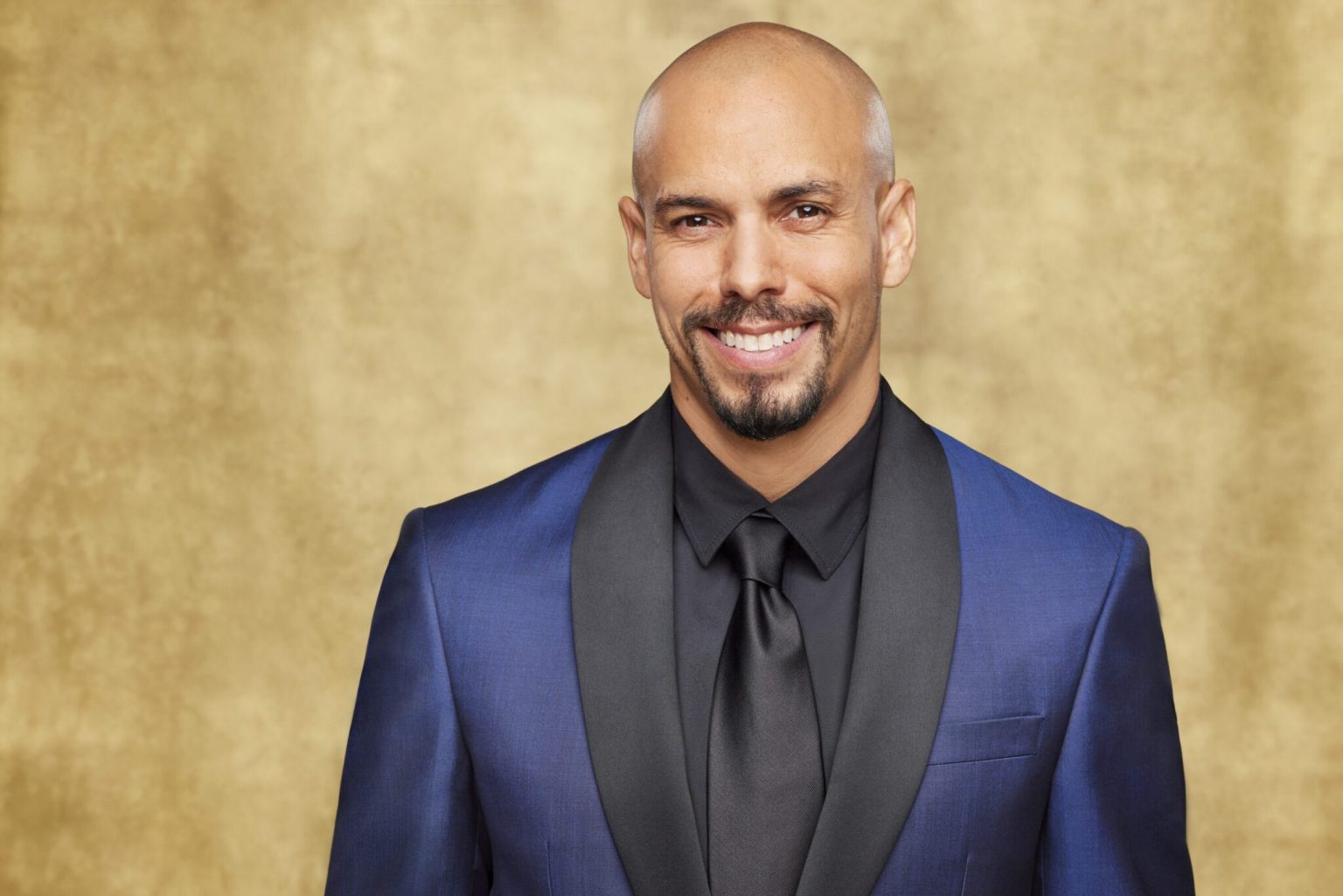 Bald man in blue suit smiling