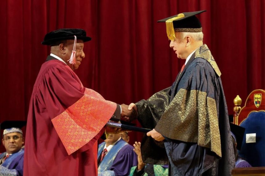 Graduation ceremony: handshake between officials on stage.