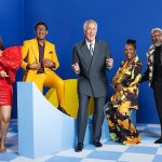 Group of five people smiling on blue background.