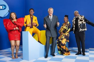 Group of five people smiling on blue background.