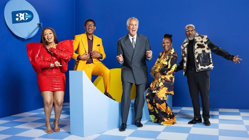 Group of five people smiling on blue background.