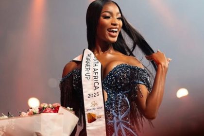 Pageant runner-up smiles with flowers on stage.