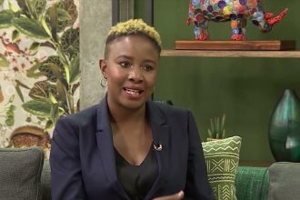 Person speaking on a vibrant, colourful set.