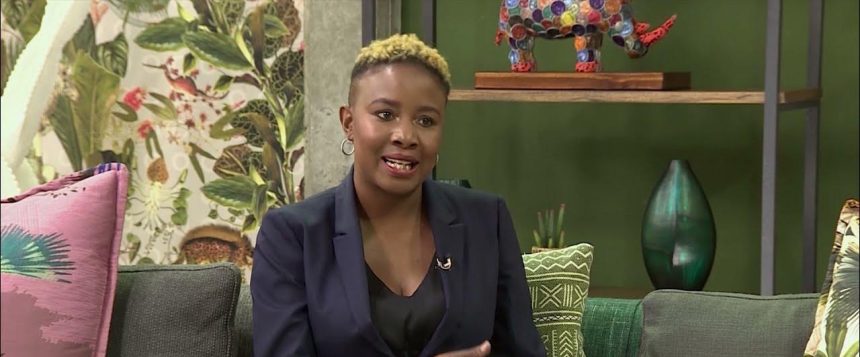 Person speaking on a vibrant, colourful set.