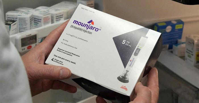 Mounjaro packaging for prescription injections held by hands.