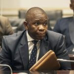 Man in suit at meeting with folder