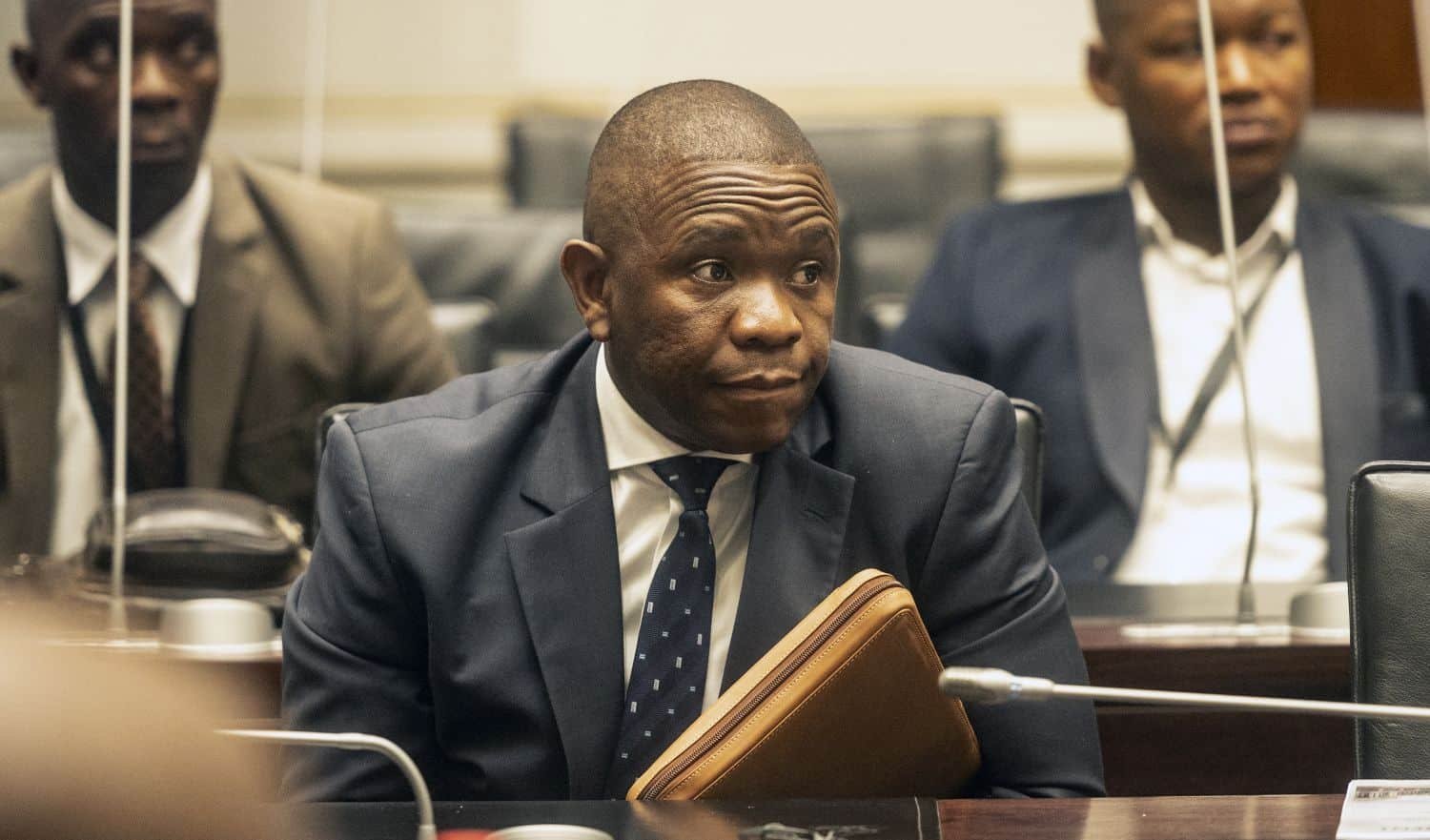 Man in suit at meeting with folder