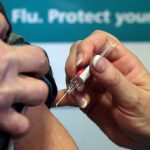 Person receiving flu vaccination injection in arm