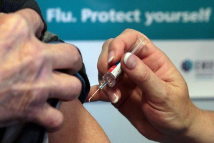 Person receiving flu vaccination injection in arm