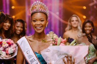 Miss South Africa winner with crown and flowers.