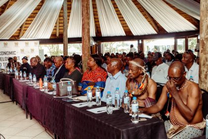 Conference attendees seated at long table.