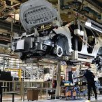 Car assembly line in factory with workers