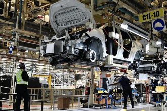 Car assembly line in factory with workers