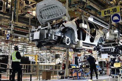 Car assembly line in factory with workers
