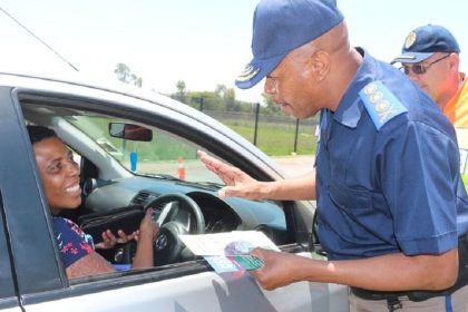 Traffic officer speaking to driver at a checkpoint.