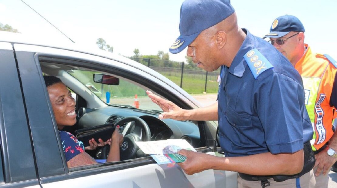 Traffic officer speaking to driver at a checkpoint.