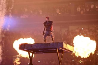 Performer on stage with dramatic fire effects
