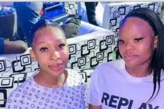 Two people smiling in a colourful room.