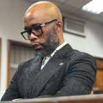 Man in courtroom thoughtful and serious expression.