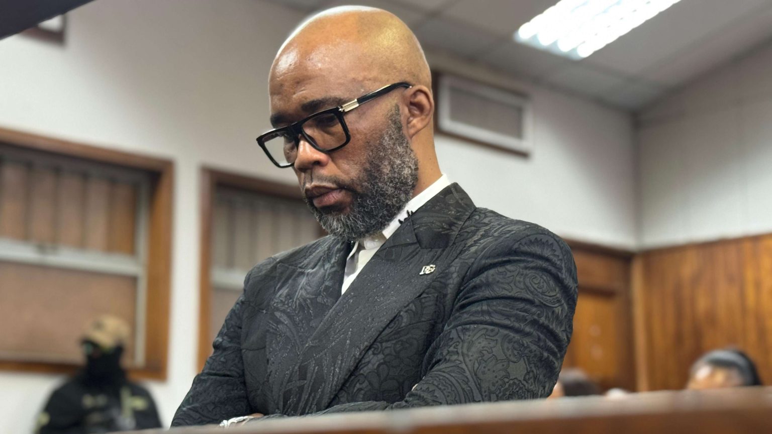 Man in courtroom thoughtful and serious expression.