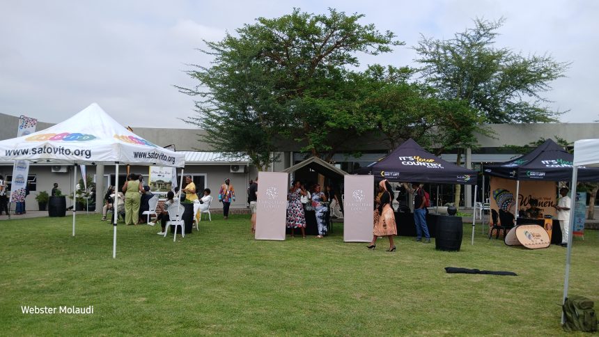 Outdoor event with tents and people gathering.