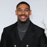 Smiling man in black jacket, grey turtleneck