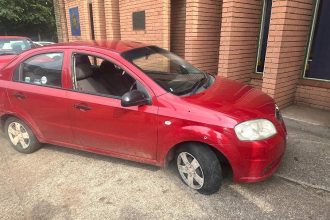 Red car with flat front tyre parked