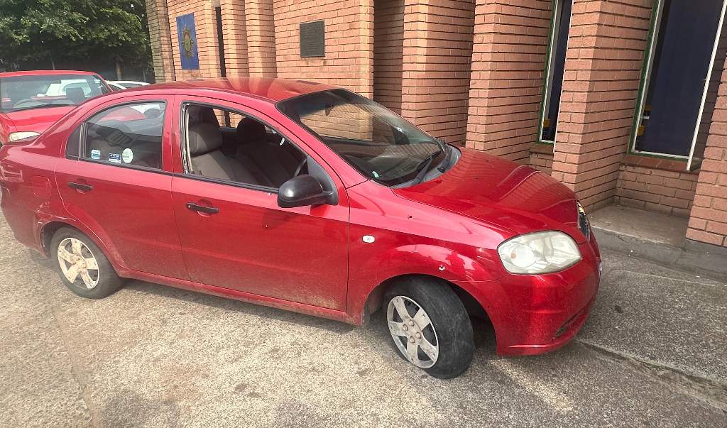 Red car with flat front tyre parked