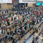 Crowd with flags at busy airport terminal