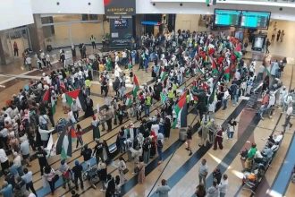 Crowd with flags at busy airport terminal