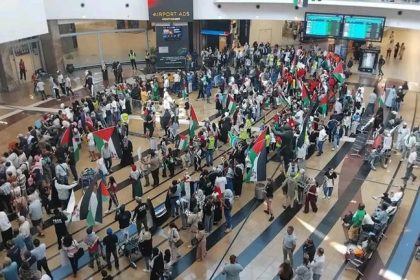 Crowd with flags at busy airport terminal