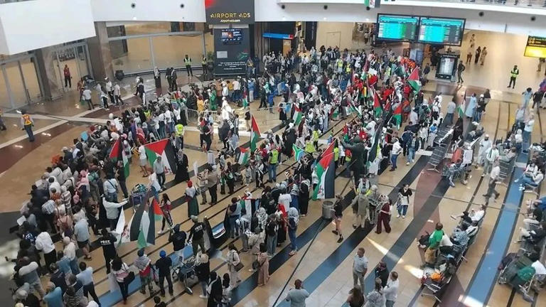 Crowd with flags at busy airport terminal