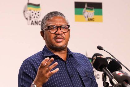 Man speaking at ANC conference with microphones