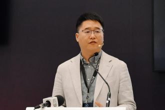 Speaker at Africa Com conference podium.