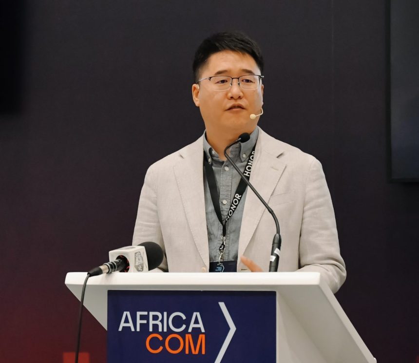 Speaker at Africa Com conference podium.