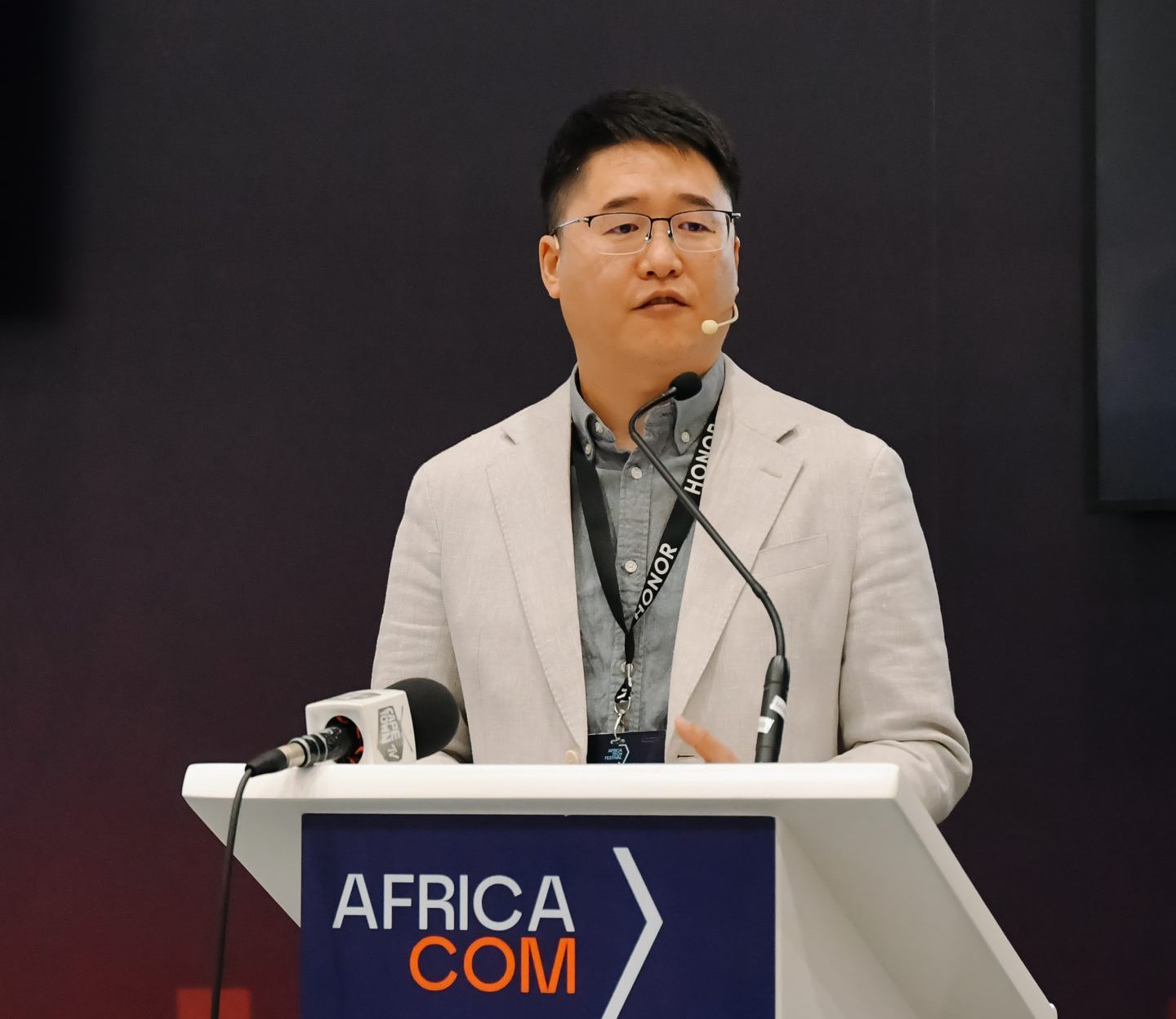Speaker at Africa Com conference podium.