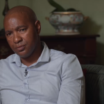 Luyanda Mboniswa sitting on a couch, looking thoughtful.
