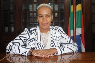 Person sitting at desk with South African flag.