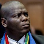 Person in formal attire with colourful scarf.