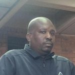 Man in black jacket inside brick building