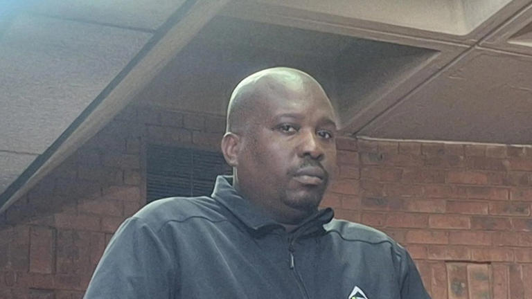 Man in black jacket inside brick building
