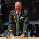 Adriaan Richter in rugby blazer at public event.