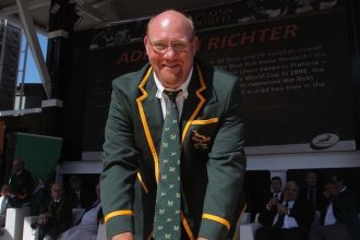Adriaan Richter in rugby blazer at public event.